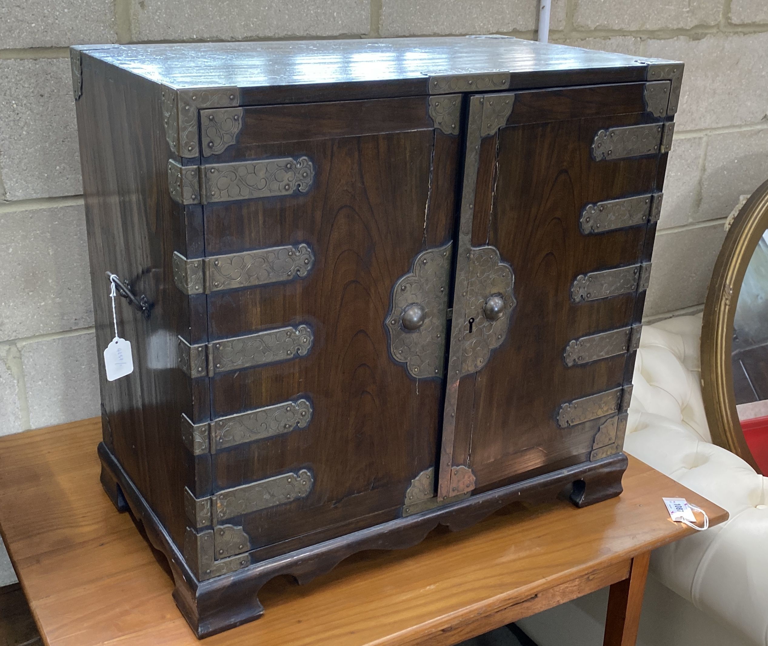 A Korean brass mounted pine table cabinet fitted with an arrangement of drawers, width 70cm, depth 40cm, height 66cm